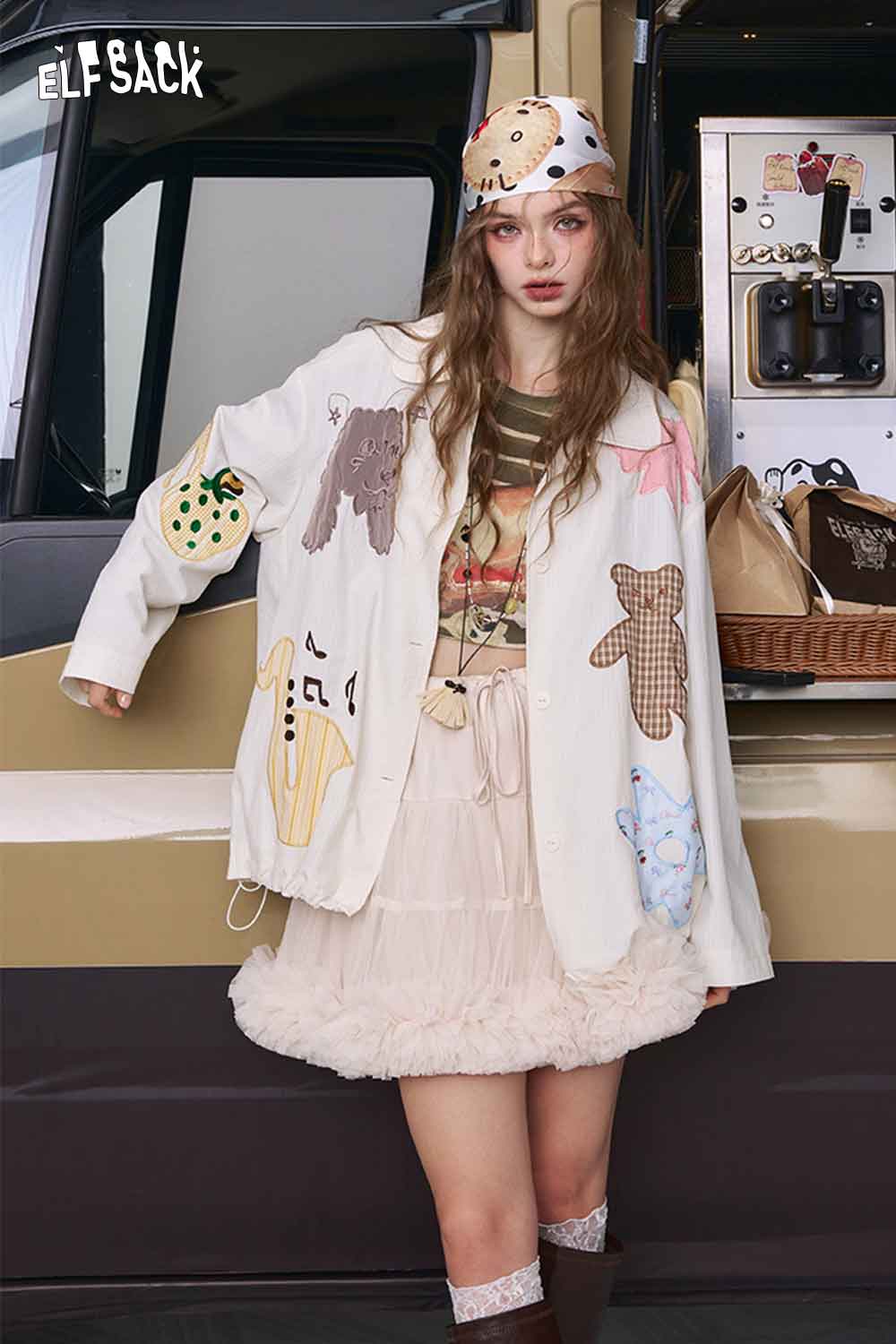 ELFSACK model wearing relaxed fit ruched stripe t-shirt layered under patched cream jacket and ruffle tulle skirt