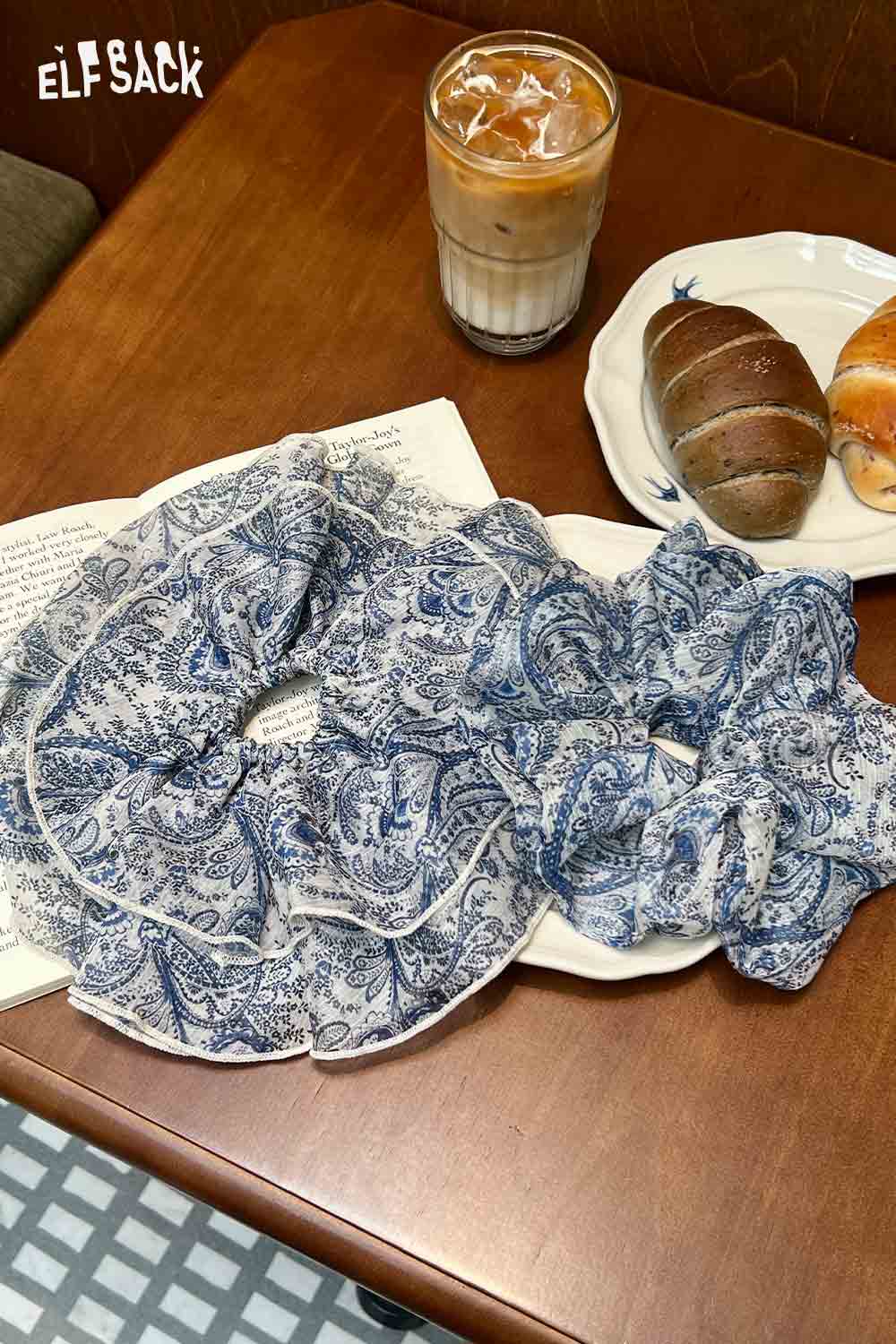 ELFSACK bohemian paisley hair tie set of blue paisley chiffon scrunchies displayed on cafe table with coffee and pastries