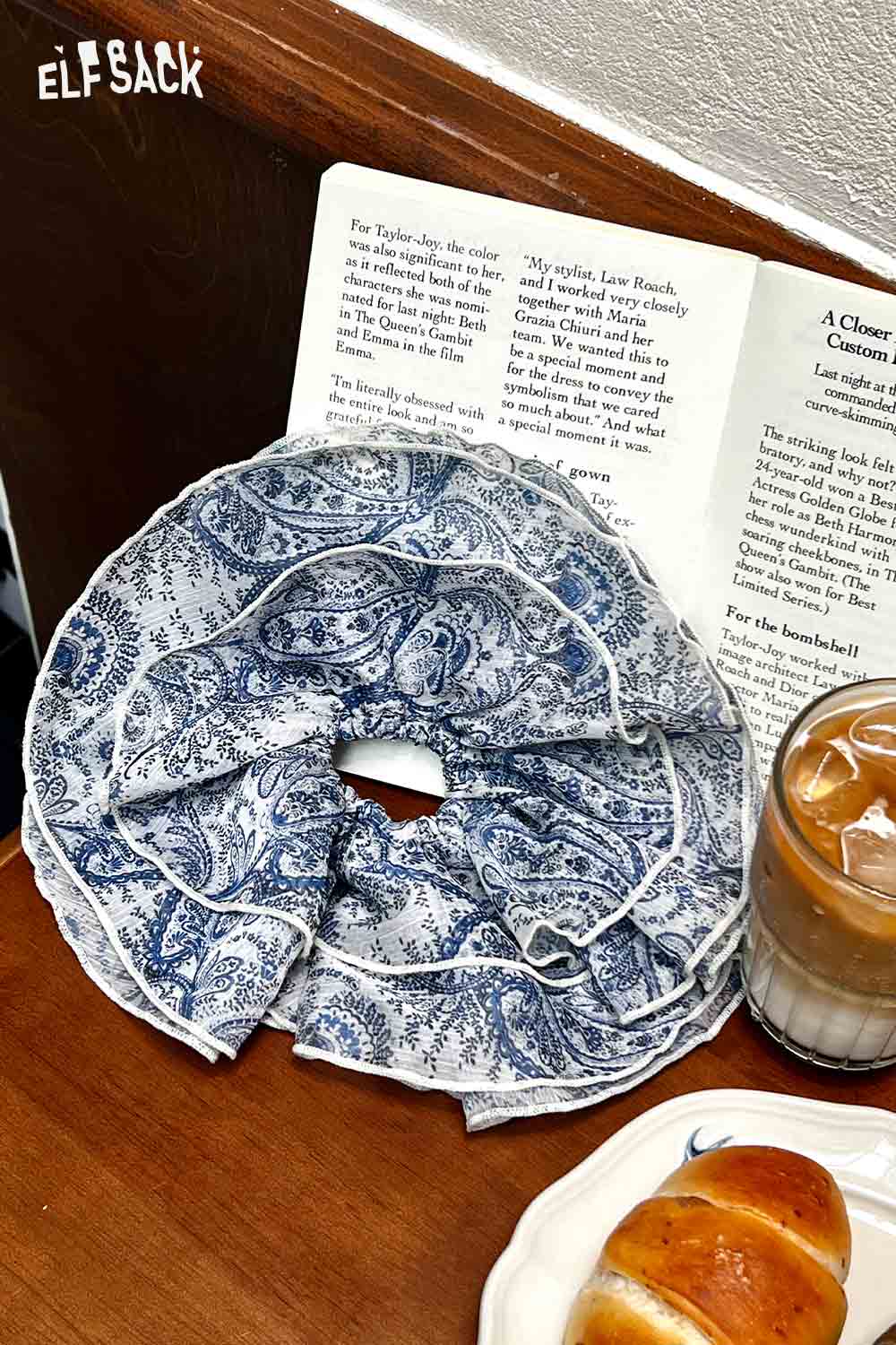 ELFSACK bohemian paisley hair tie blue ruffle scrunchie on wooden table with open book iced coffee and pastry