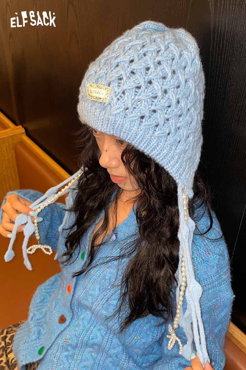 ELFSACK crocheted tassel ear-flap hat in light blue with intricate knit design and tassels