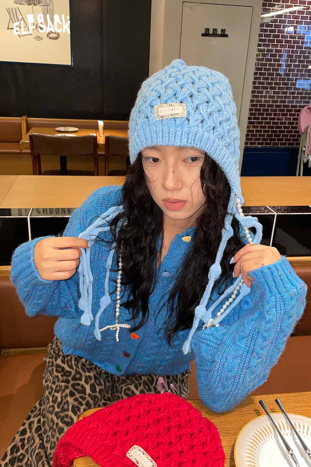 ELFSACK crocheted tassel ear-flap hat in light blue, perfect for warmth and style this winter
