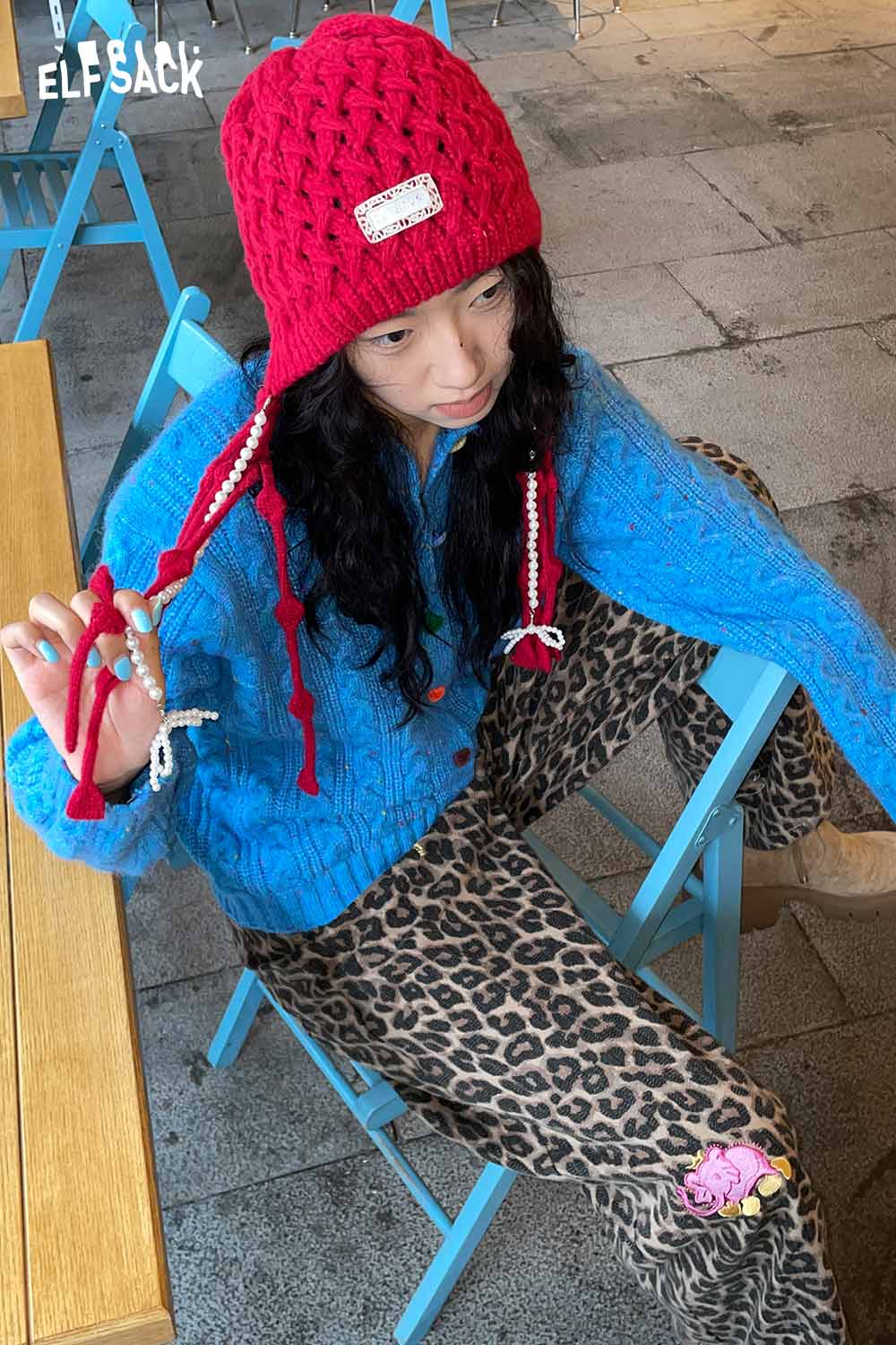 ELFSACK Crocheted tassel ear-flap hat in red, perfect for stylish winter warmth and cozy looks