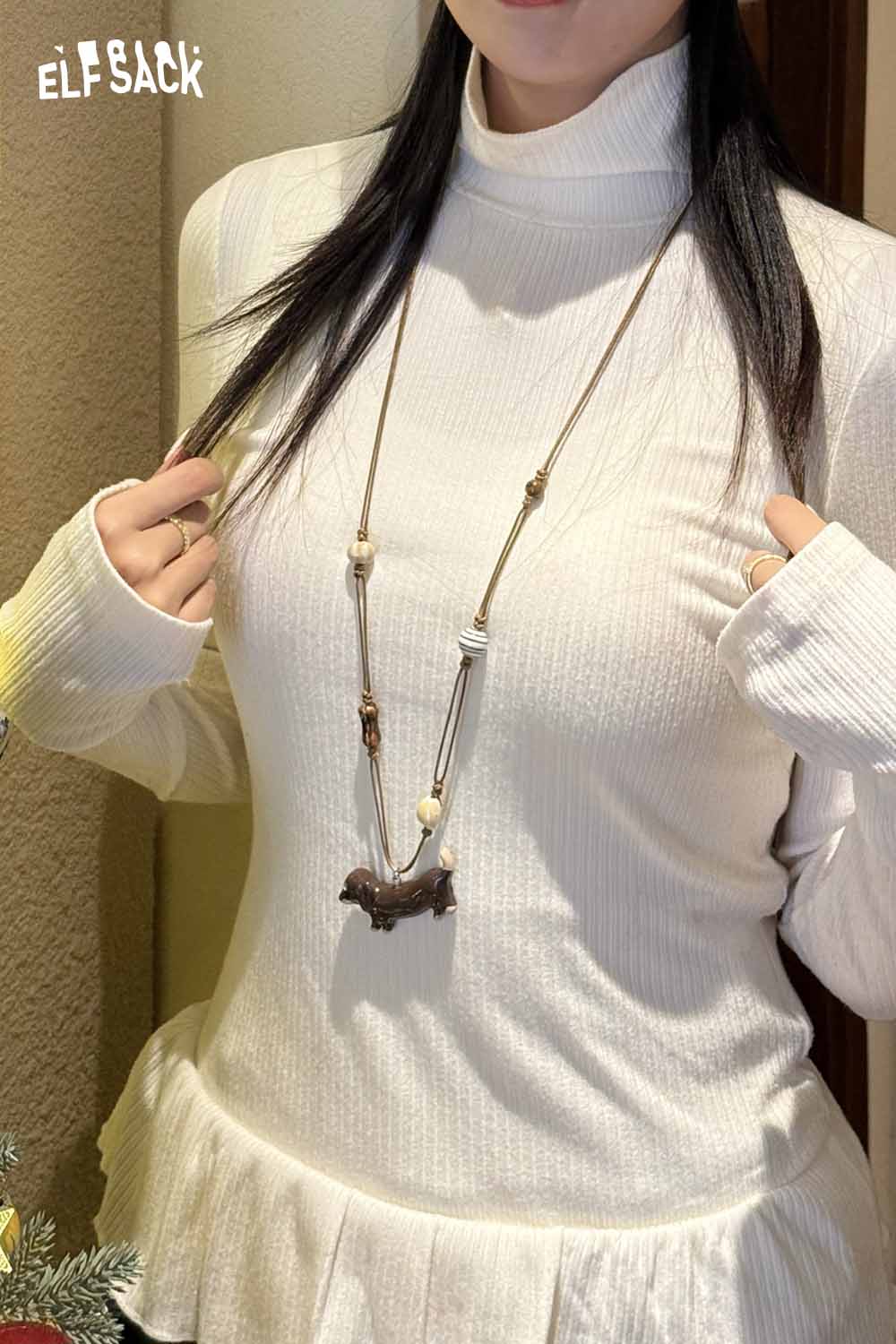 ELFSACK cute dog pendant necklace worn over a white ribbed turtleneck top with a peplum hem