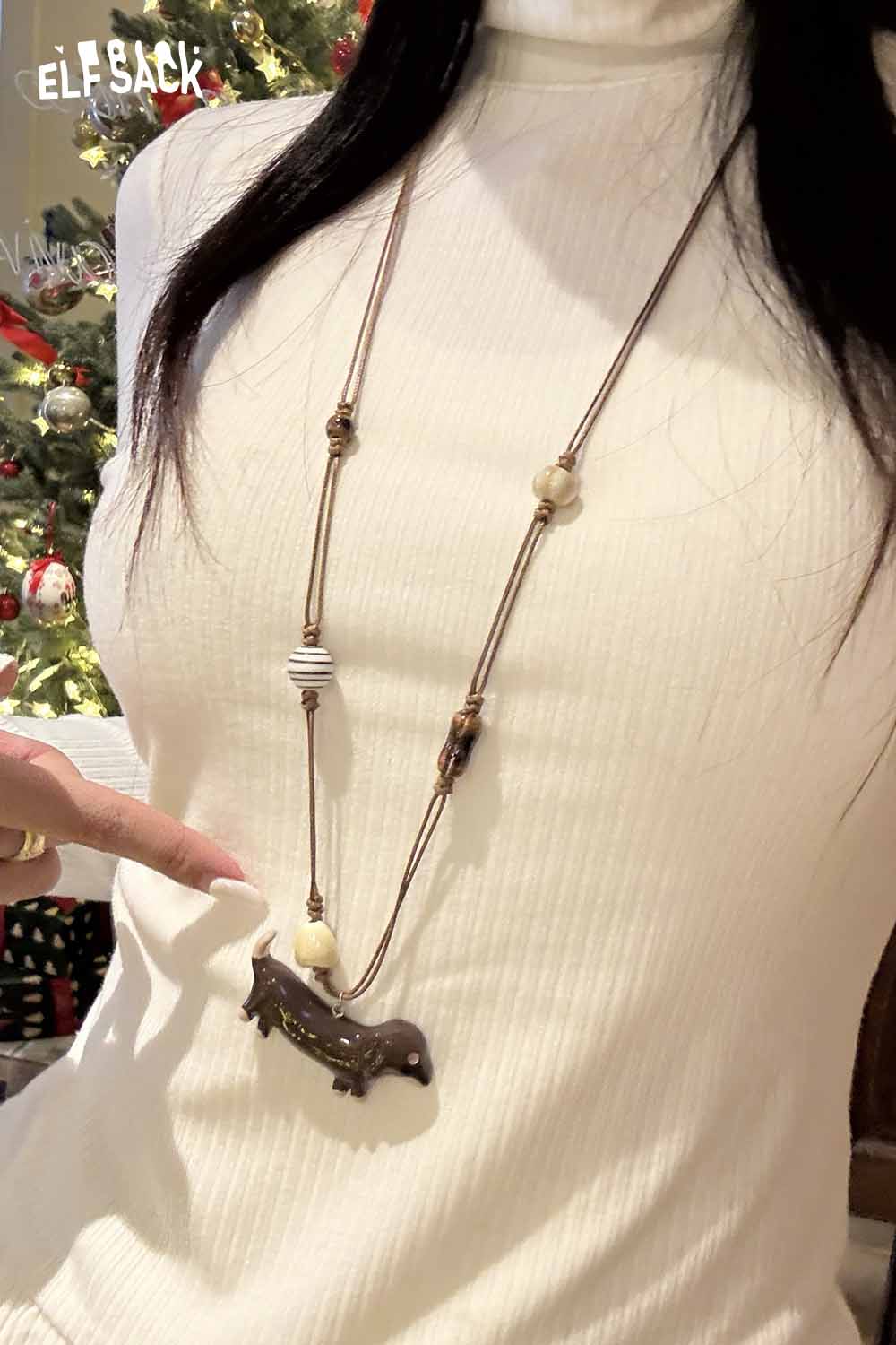 ELFSACK Cute dog pendant necklace showcased on a model with a holiday backdrop