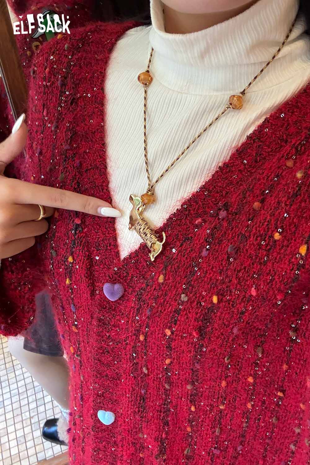 Model wearing a red knit sweater showcasing a cute dog pendant necklace with a textured finish