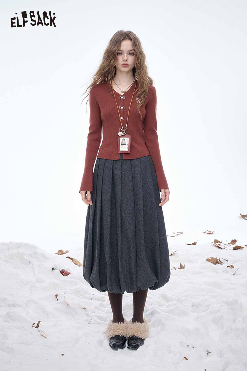 ELFSACK dark gray pleated half skirt styled with a brown button-up top in a snowy setting
