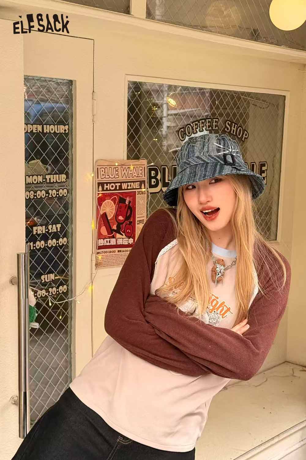 ELFSACK denim sequin bucket hat displayed by a model outside a coffee shop