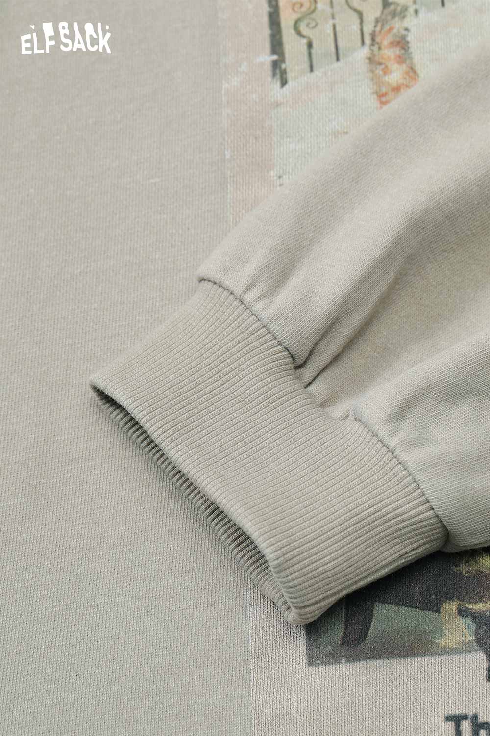 Close-up of ELFSACK distressed cotton jersey long sleeve tee showcasing ribbed cuff and graphic detail