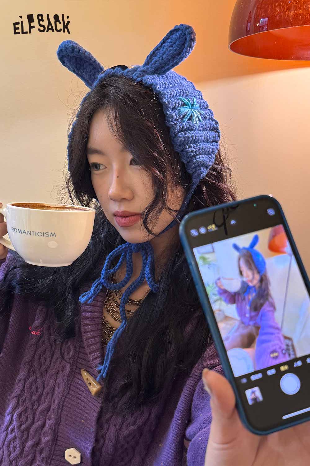 ELFSACK 3D bunny ear knit ear warmers in blue worn by a woman holding a coffee cup