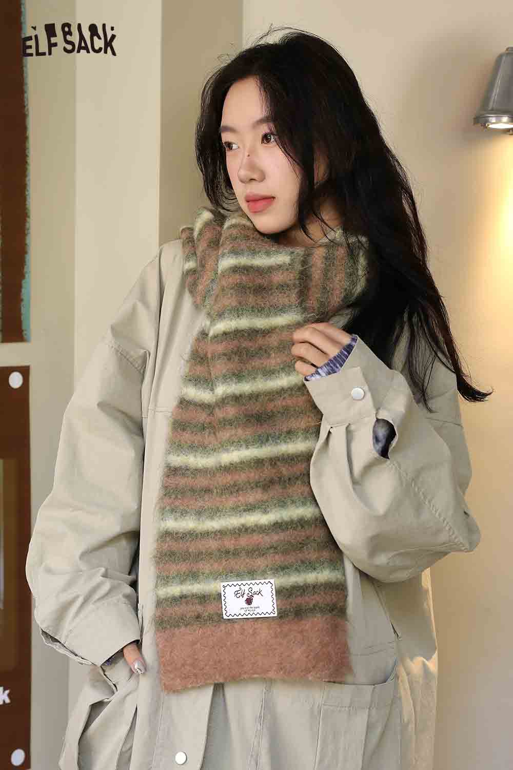 Cozy Christmas striped scarf for women in soft, multicolored fibers, paired with a relaxed outerwear look