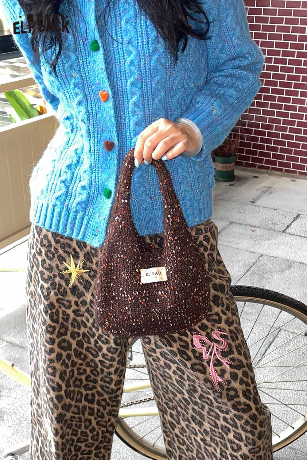 ELFSACK color block handwoven tote bag held by a person wearing a blue sweater and leopard print pants