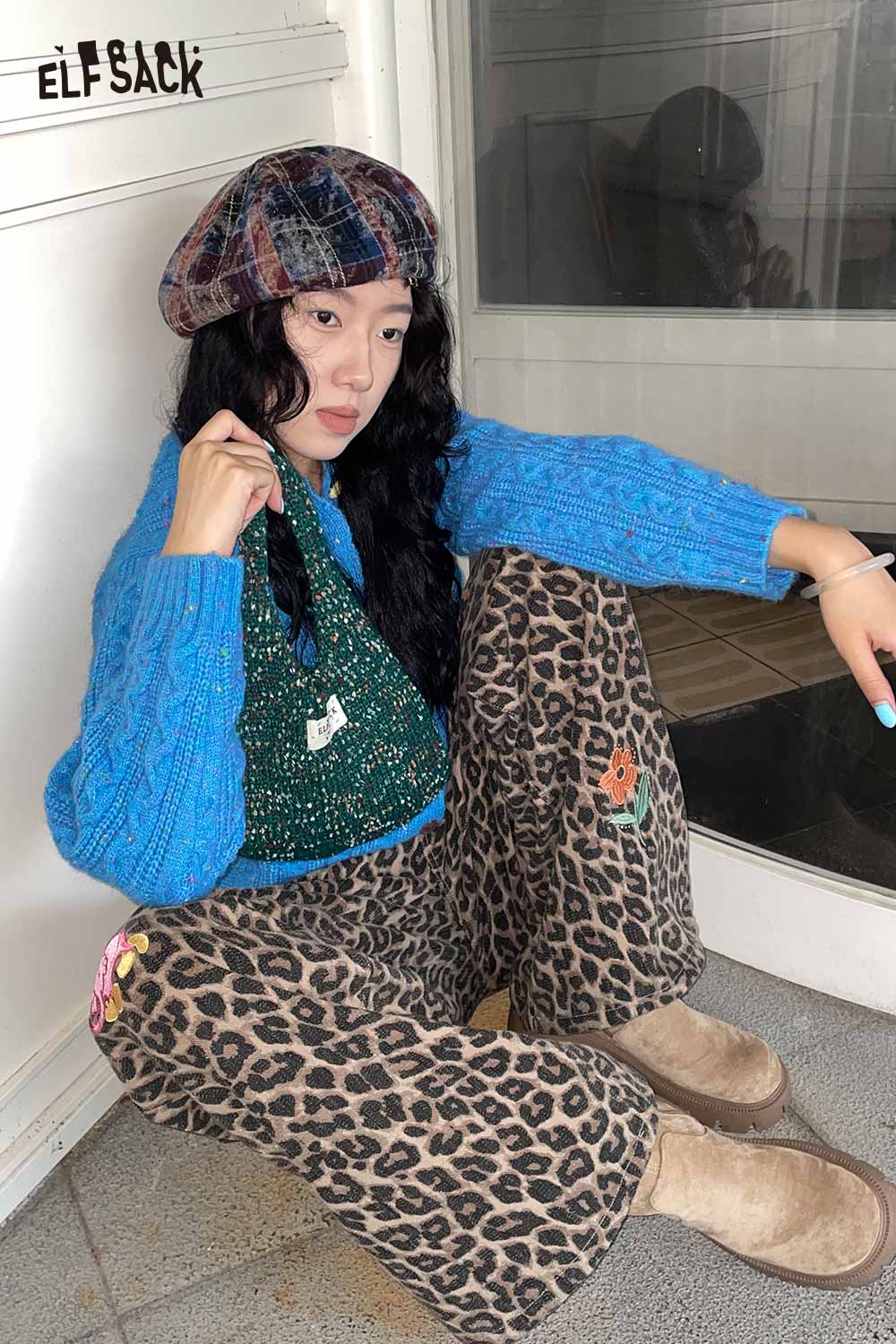 Color block handwoven tote bag in green, styled with cozy blue sweater and leopard print pants