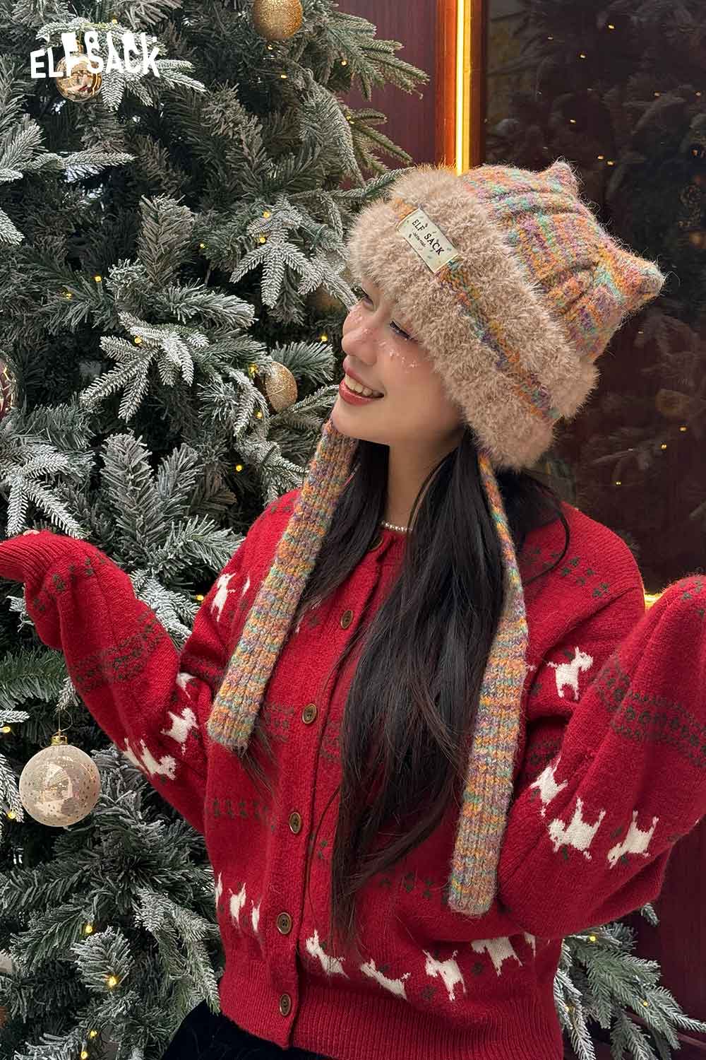 Woman wearing a cute cat ear beanie for women, styled with a cozy red cardigan in a festive setting