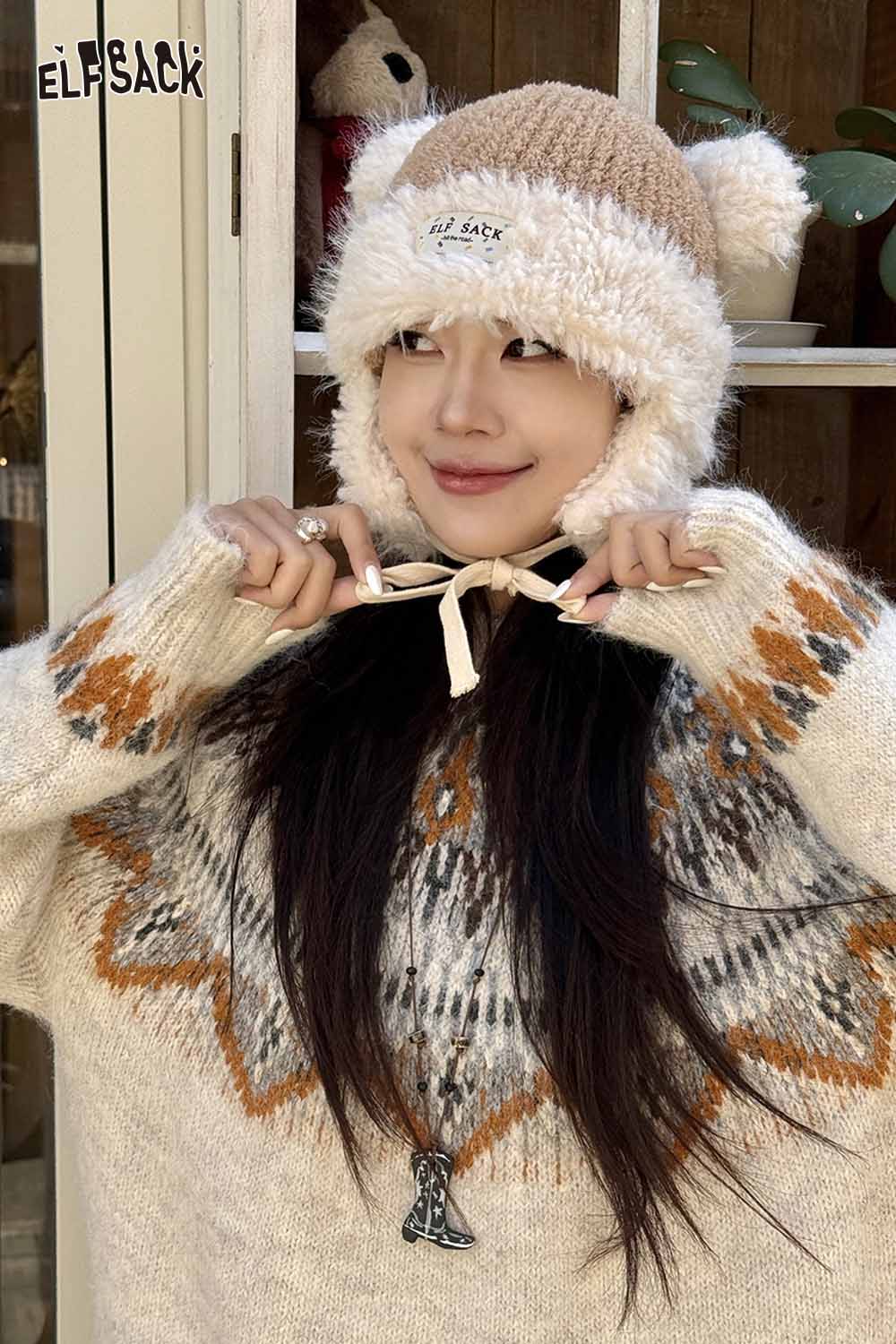 Woman wearing a cute plush ear flap hat paired with a cozy sweater from ELFSACK