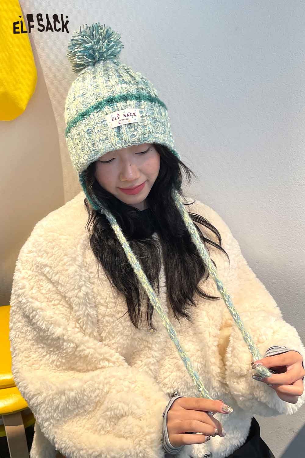 Cute striped pom beanie for women in fluffy style with ties and a soft texture