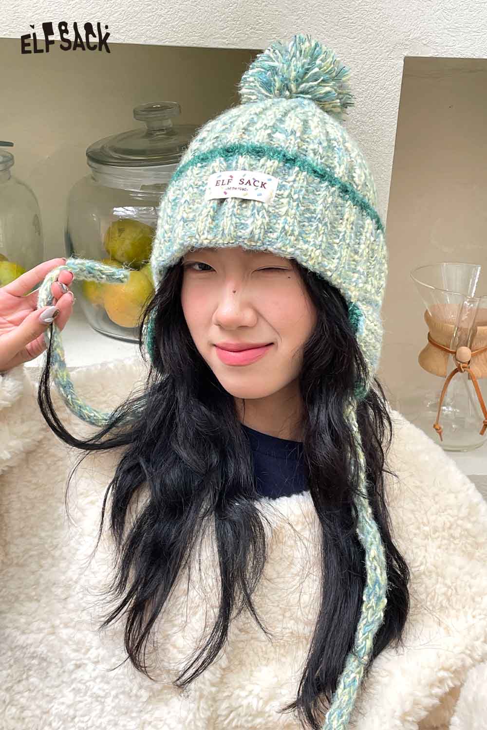 Woman wearing a cute striped pom beanie for women with braided ties and cozy style