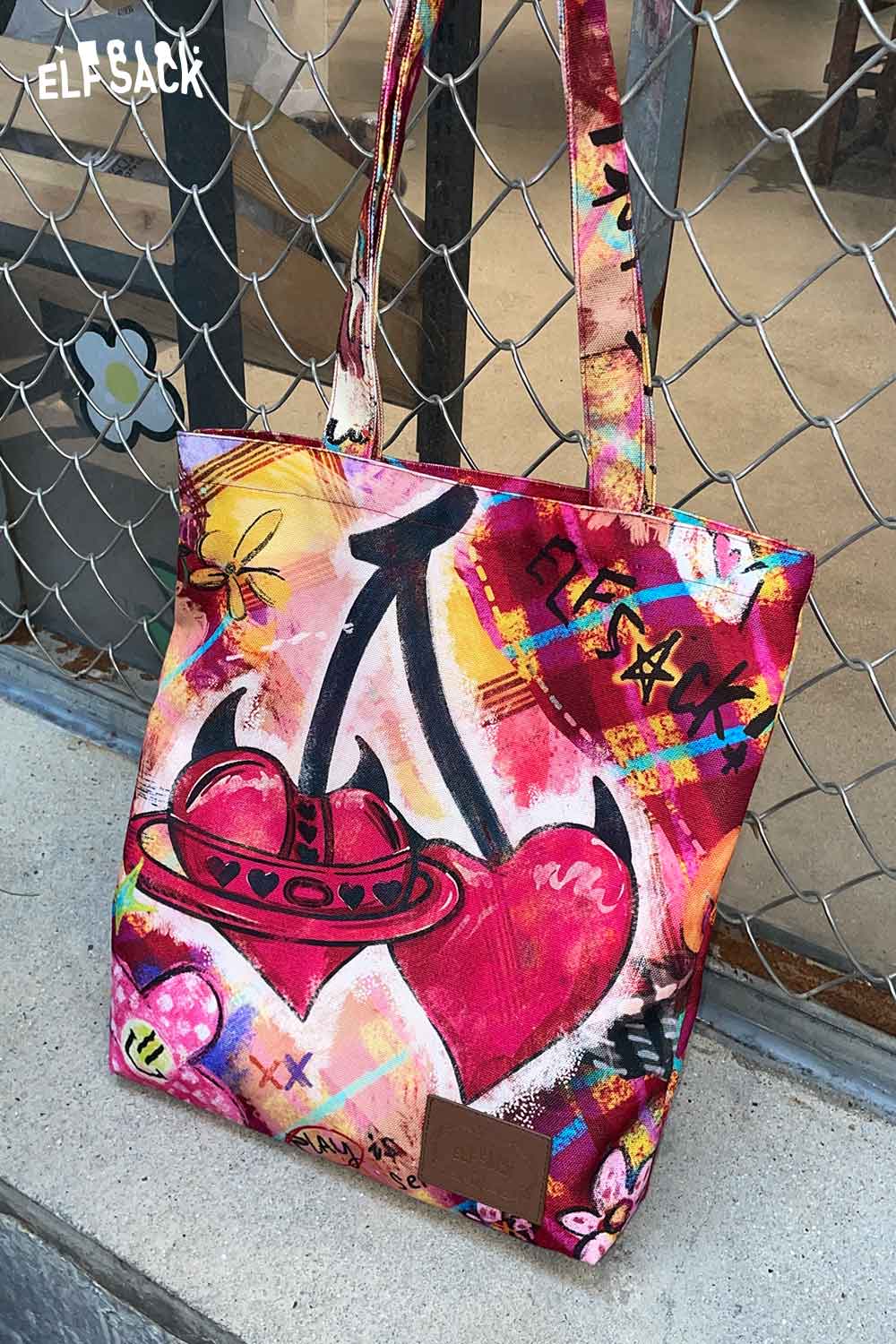 Colorful ELFSACK plaid graffiti tote bag featuring vibrant artistic designs and sturdy handles