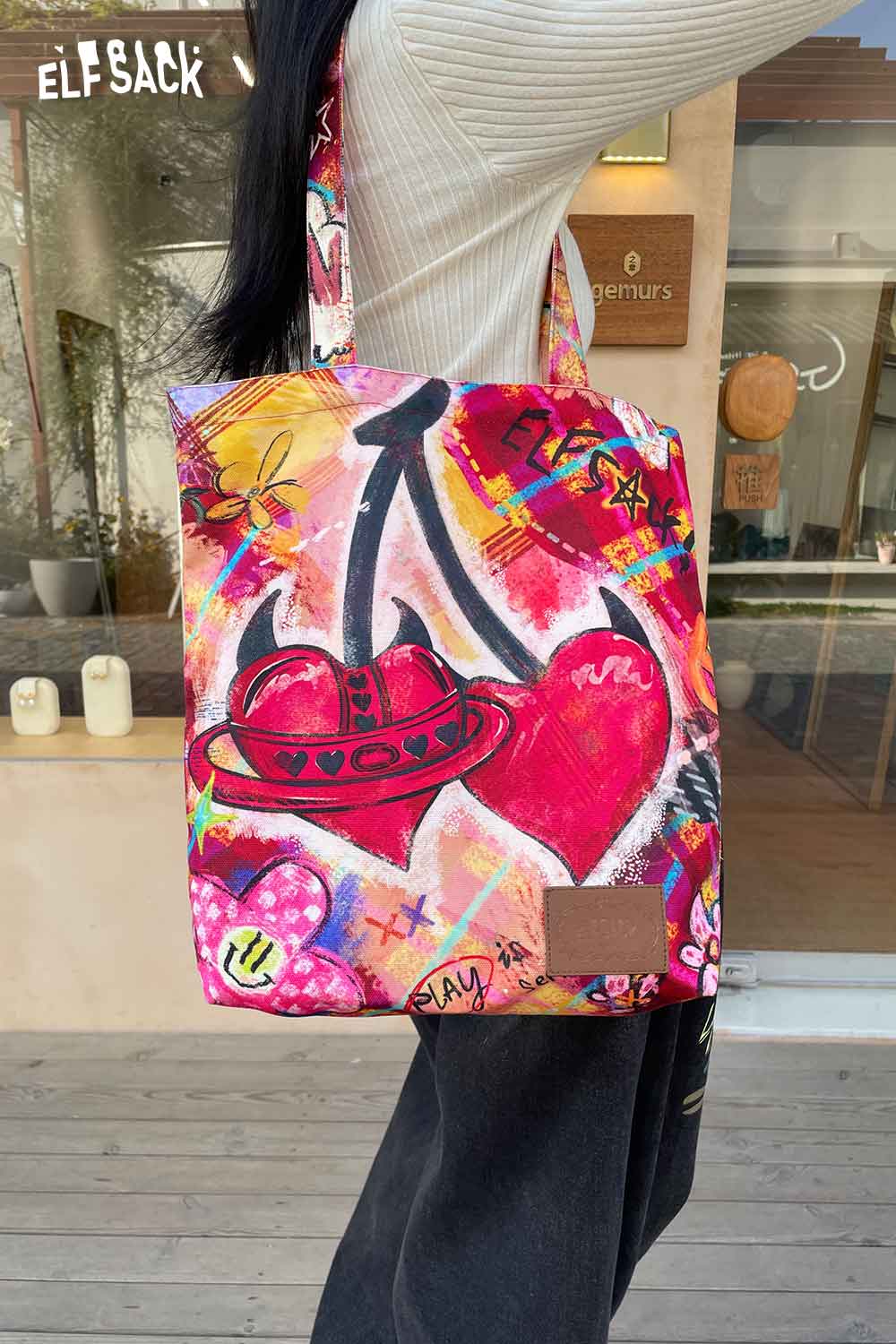 Colorful ELFSACK plaid graffiti tote bag featuring vibrant graffiti designs and comfortable shoulder straps