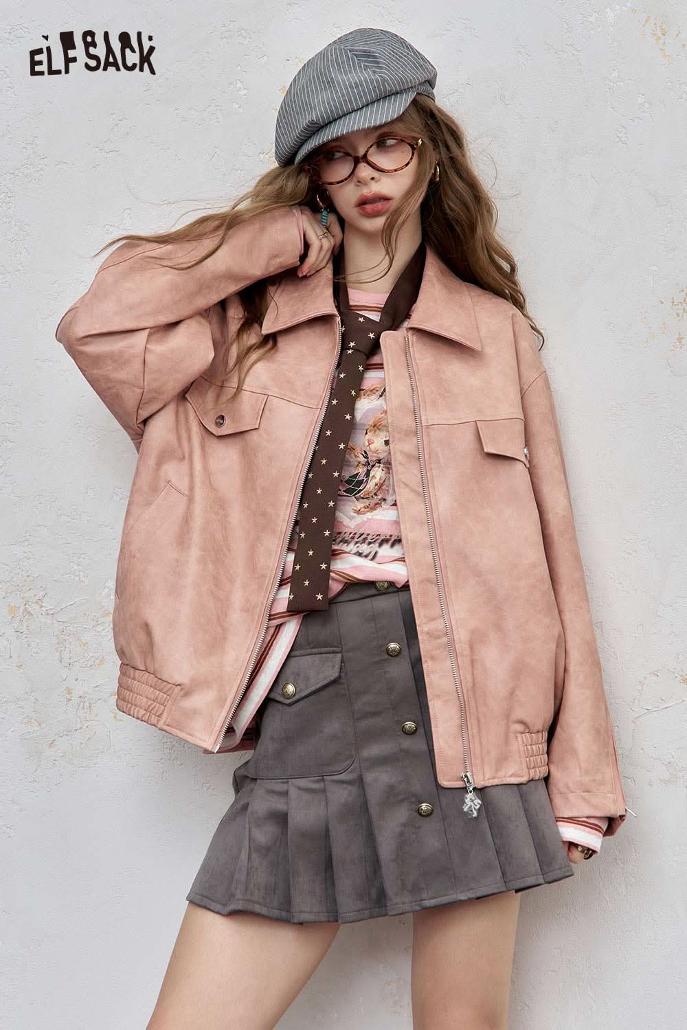 Stylish woman wearing a playful embroidered stripe shirt paired with a pink jacket and grey skirt