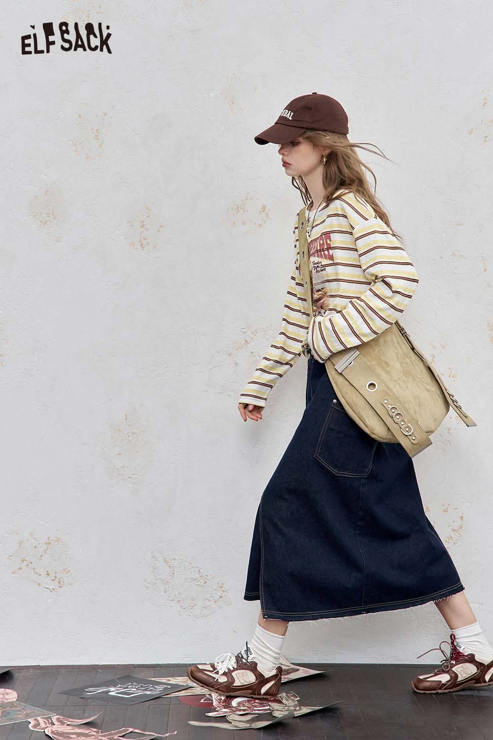 Styled model wearing a playful embroidered stripe shirt with a long denim skirt and accessories