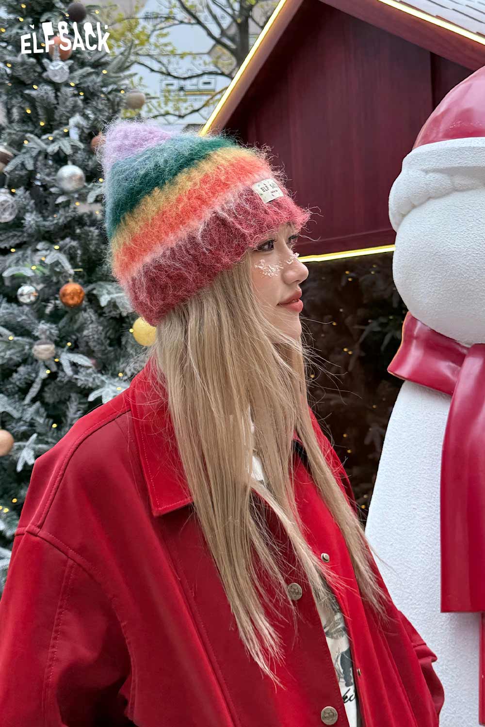 ELFSACK rainbow striped knit beanie worn by a model outdoors in casual attire