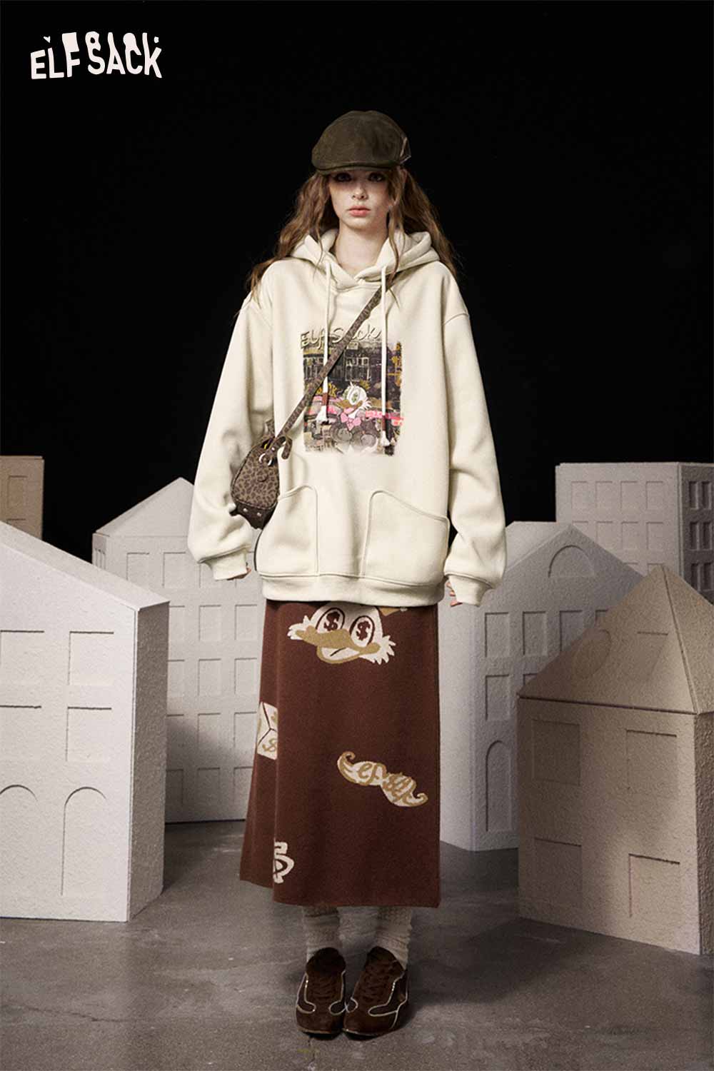 ELFSACK soft graphic hooded sweatshirt in cream with a playful design, paired with a brown skirt