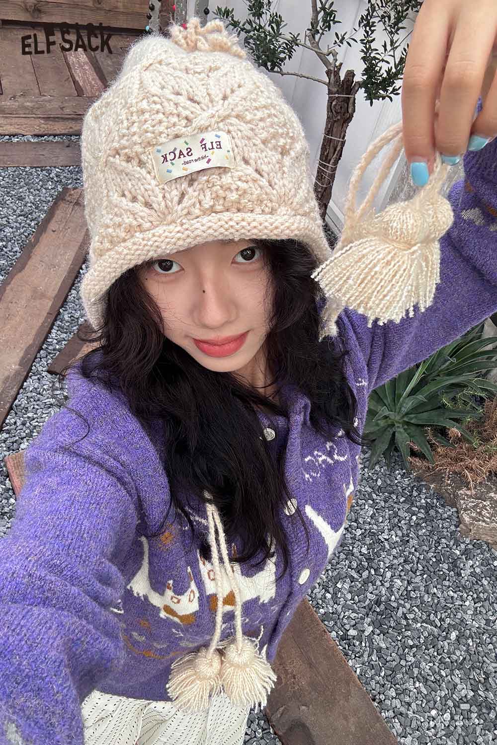 Woman wearing a beige women's braided tassel bucket hat with a stylish knitted design from ELFSACK