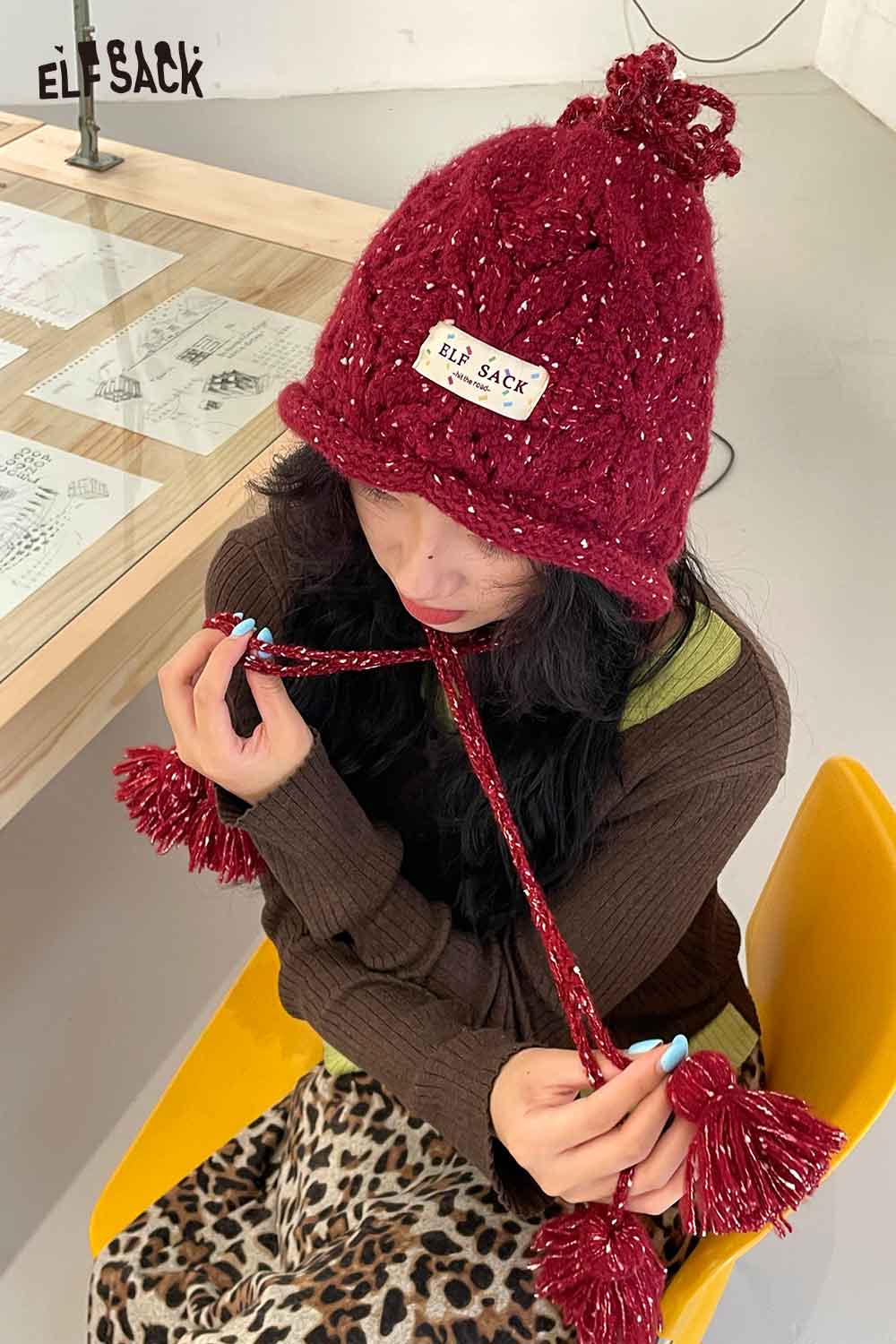 Fashionable ELFSACK women's braided tassel bucket hat in red with playful tassels and cozy knit design