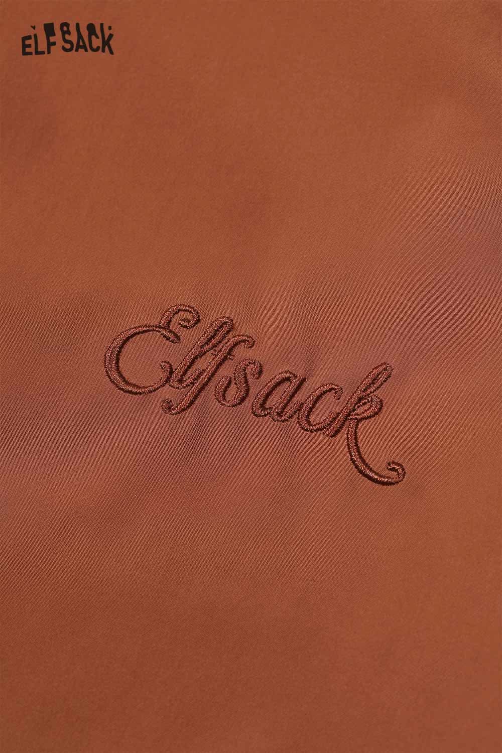 Close-up of ELFSACK logo on a breathable checkered graphic jacket for women in rust color