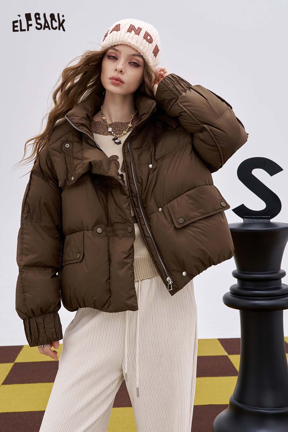 ELFSACK soft graphic knit sweater paired with a stylish puffer jacket and chic beige pants