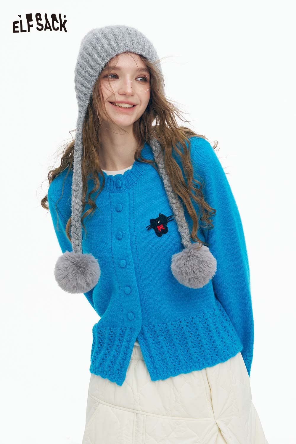 Cute knit embroidered sweater for women in bright blue paired with a fun gray pompom hat