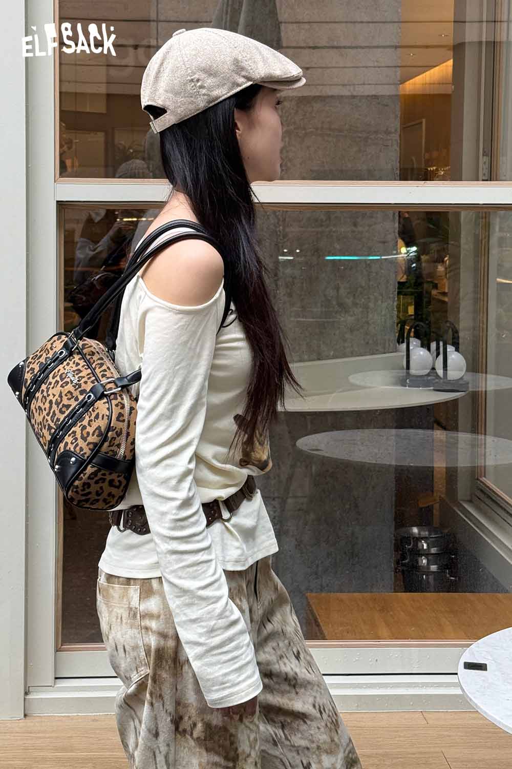 Fashionable woman wearing a leopard print crossbody bag, stylishly dressed for a casual outing