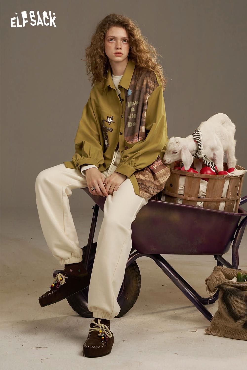 Stylish model wearing ELFSACK white cropped sweat pants for women with an oversized shirt and casual footwear