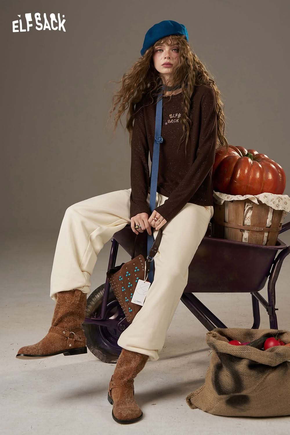 ELFSACK white cropped sweat pants for women paired with a brown top and accessories in a stylish setting