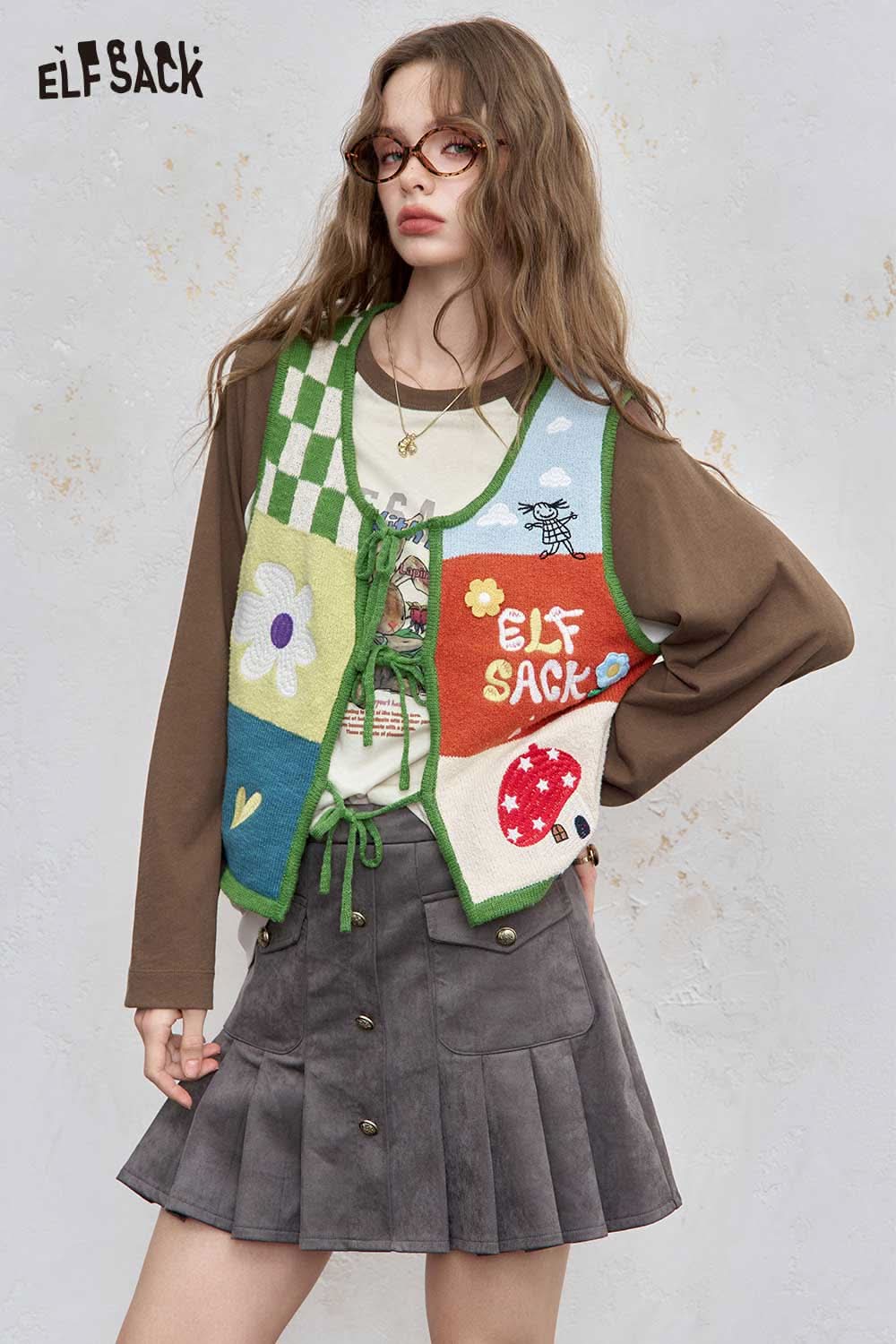 Stylish ELFSACK women's raglan sleeve graphic tee layered with a colorful vest, perfect for casual wear