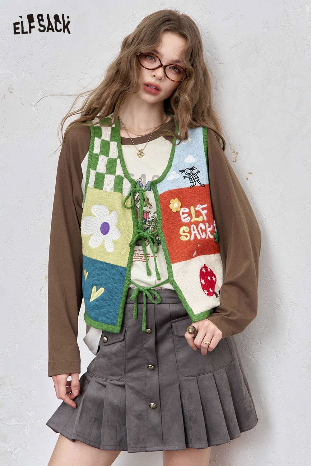 ELFSACK women's raglan sleeve graphic tee styled with a colorful vest and skirt for a trendy look