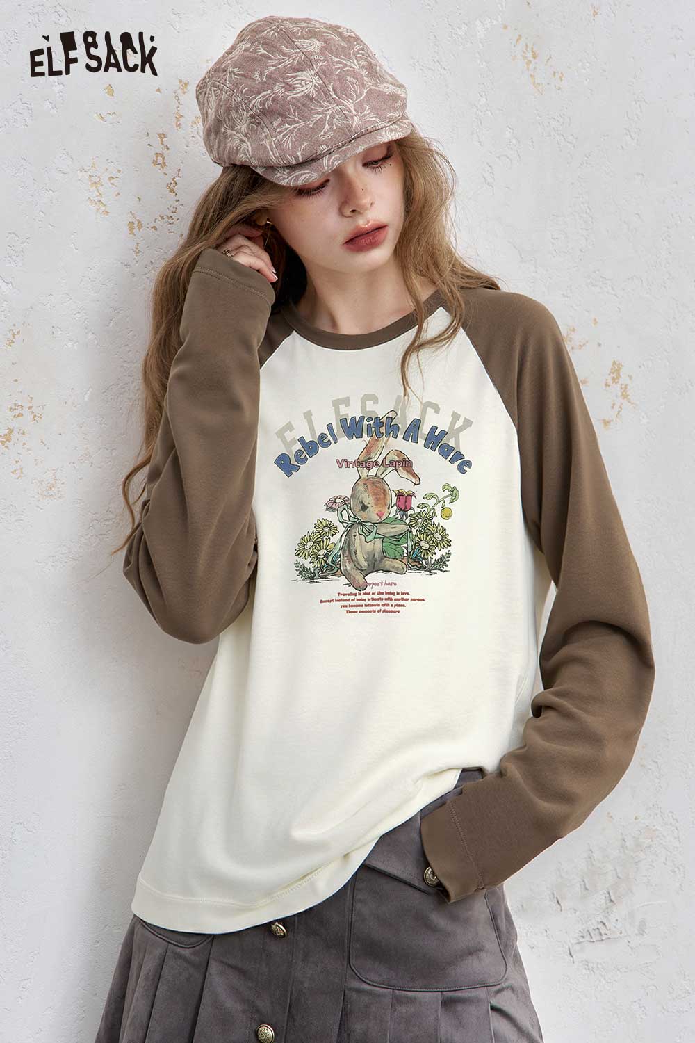ELFSACK women's raglan sleeve graphic tee featuring a playful retro design and cozy fit