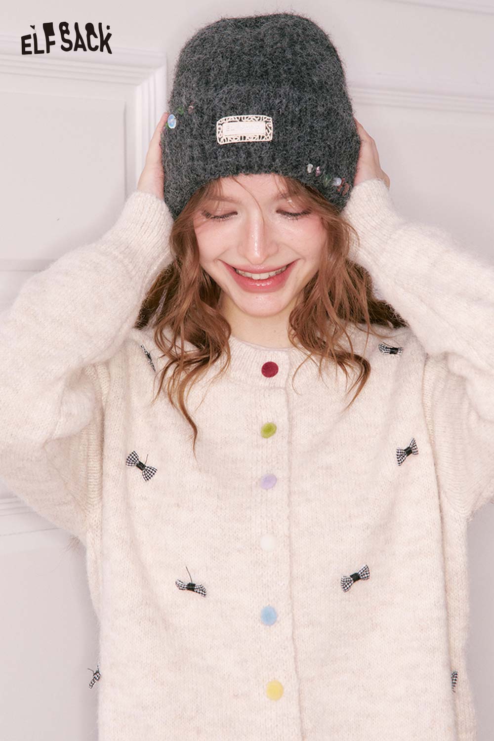 Women's solid color beanie in gray styled with a cozy sweater, perfect for winter fashion