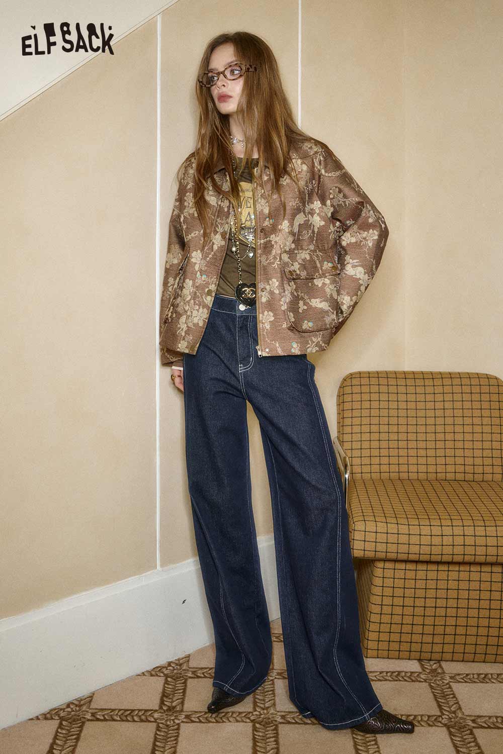 Model wearing a chic outfit featuring an embroidered fitted long sleeve tee and stylish wide-leg jeans