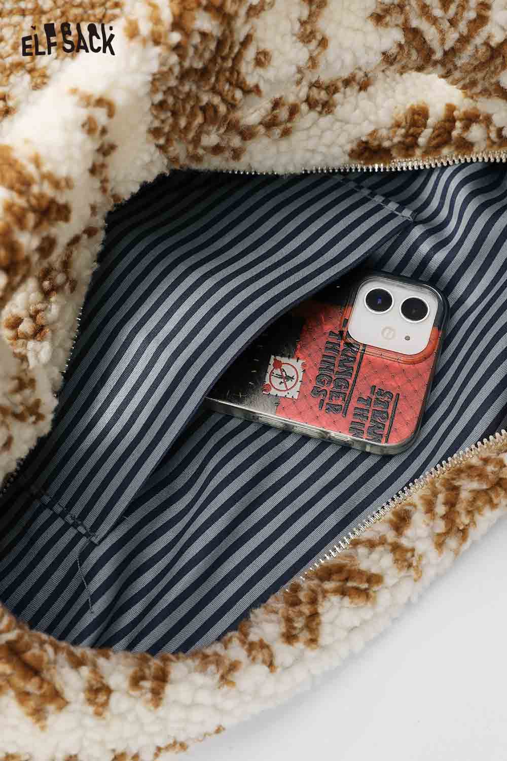 Interior view of ELFSACK Fair Isle tote bag showing striped lining and a smartphone inside