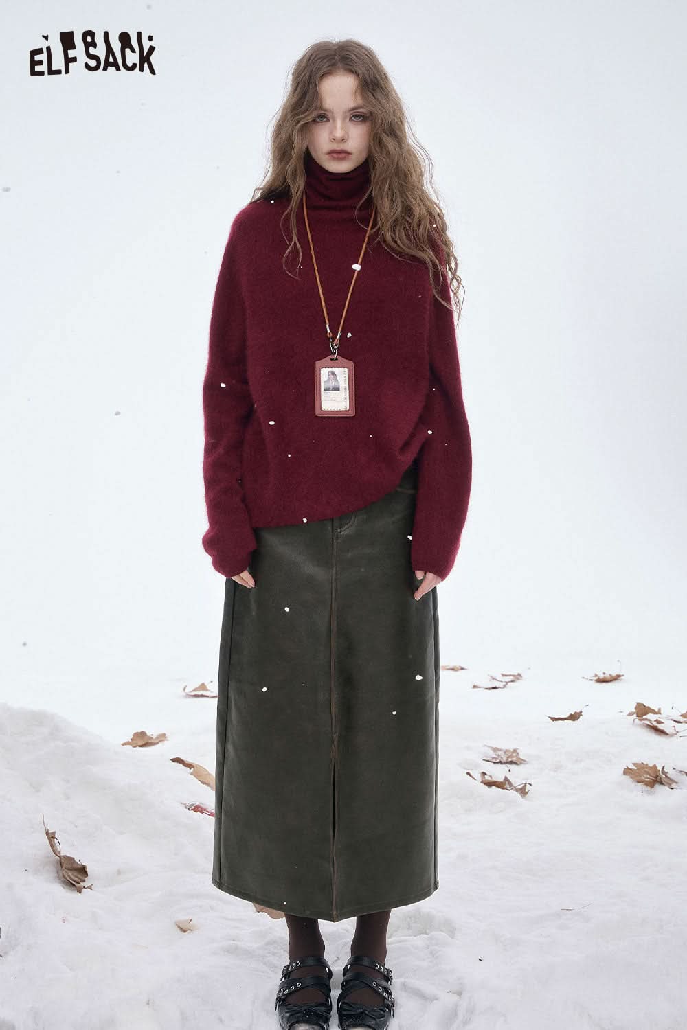Woman wearing a stylish faux leather maxi skirt with a cozy red sweater outdoors in winter