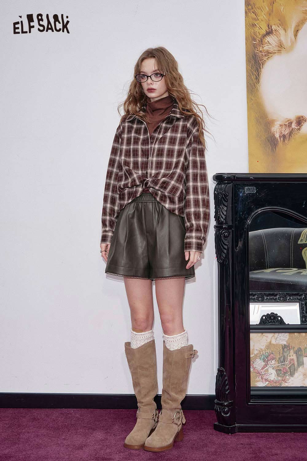 ELFSACK stylish model wearing faux leather shorts for women paired with a plaid shirt and tall boots