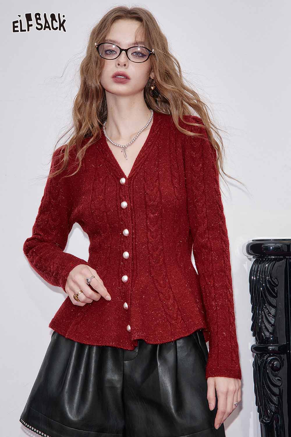 Stylish ELFSACK faux leather shorts for women paired with a red cable knit cardigan