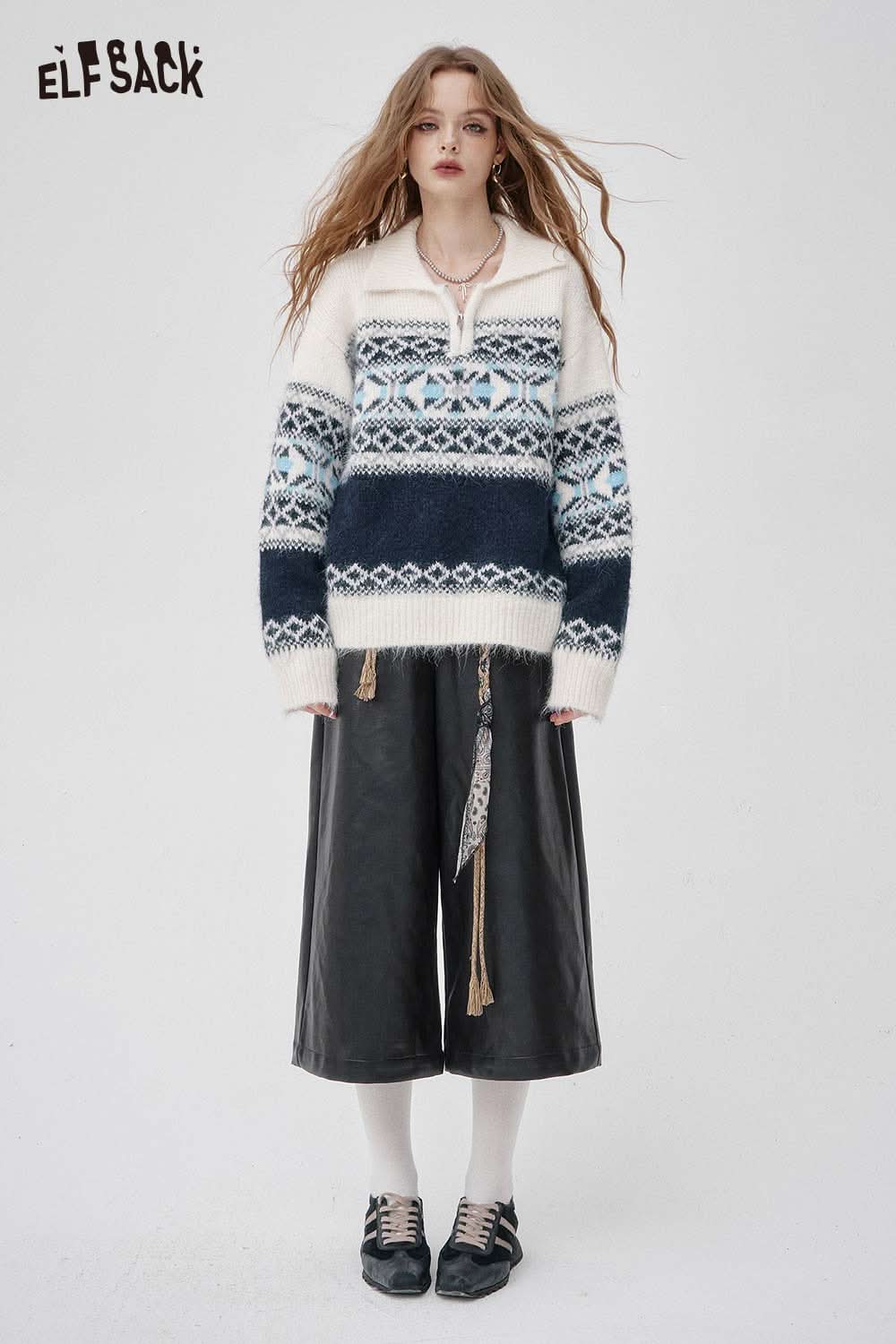 Woman wearing faux leather wide leg trousers paired with a cozy patterned sweater for a stylish look