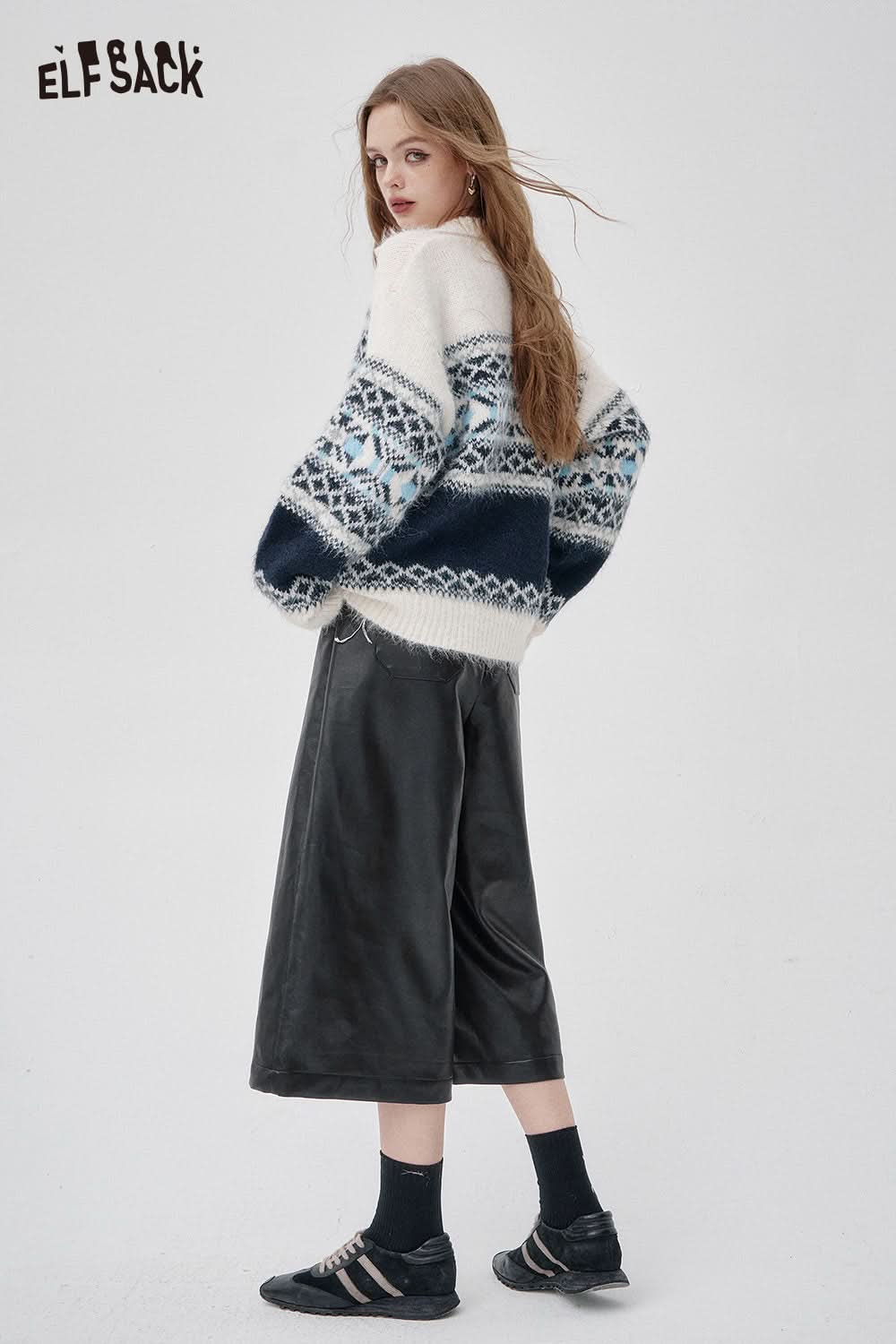 Woman wearing faux leather wide leg trousers styled with a cozy sweater for a chic look