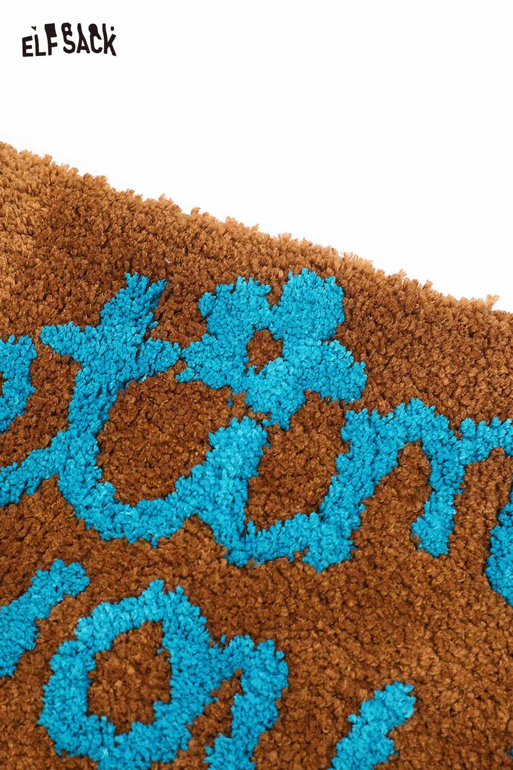 Felted wool rug with typography featuring vibrant blue lettering on a warm brown background