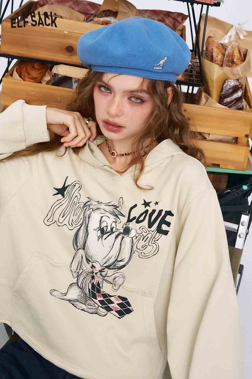 ELFSACK model wearing cream graphic hoodie with cartoon dog and LOVE print American style print hoodie for women.