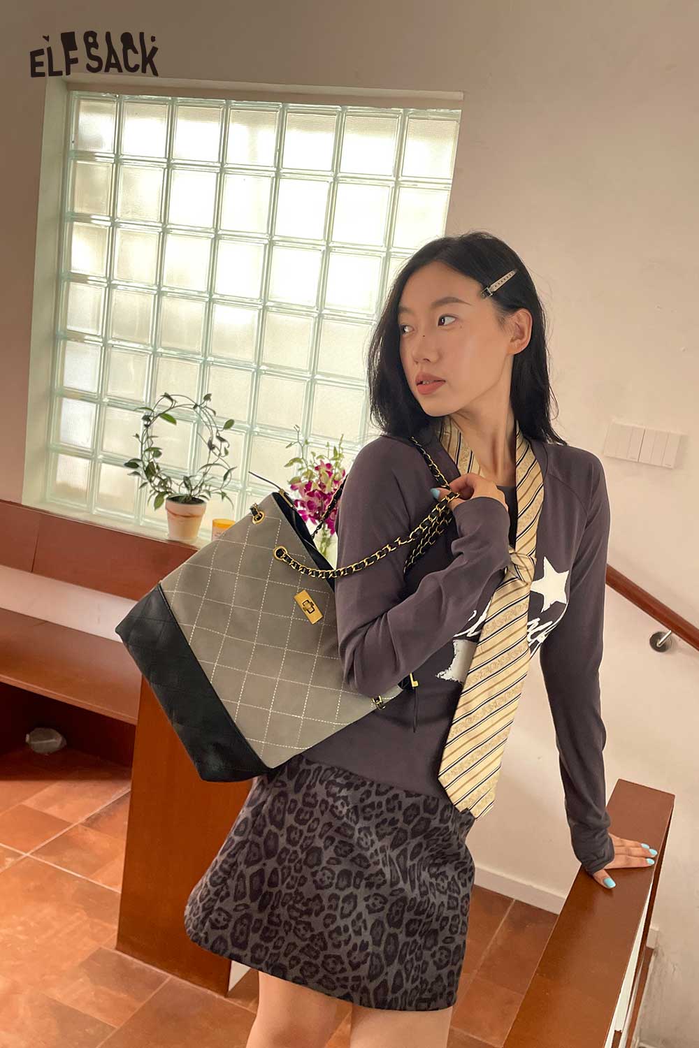 Fashionable woman wearing genuine leather bucket bag with a stylish outfit and accessories