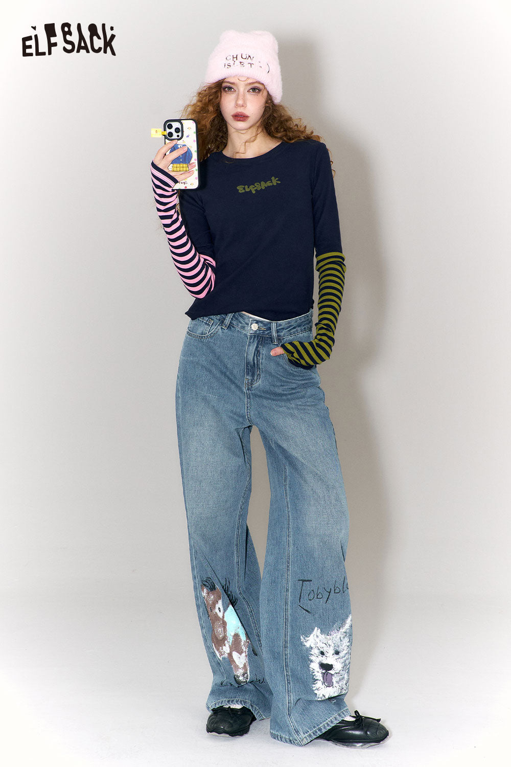 ELFSACK graffiti animal print wide leg jeans styled with a navy top and colorful striped sleeves