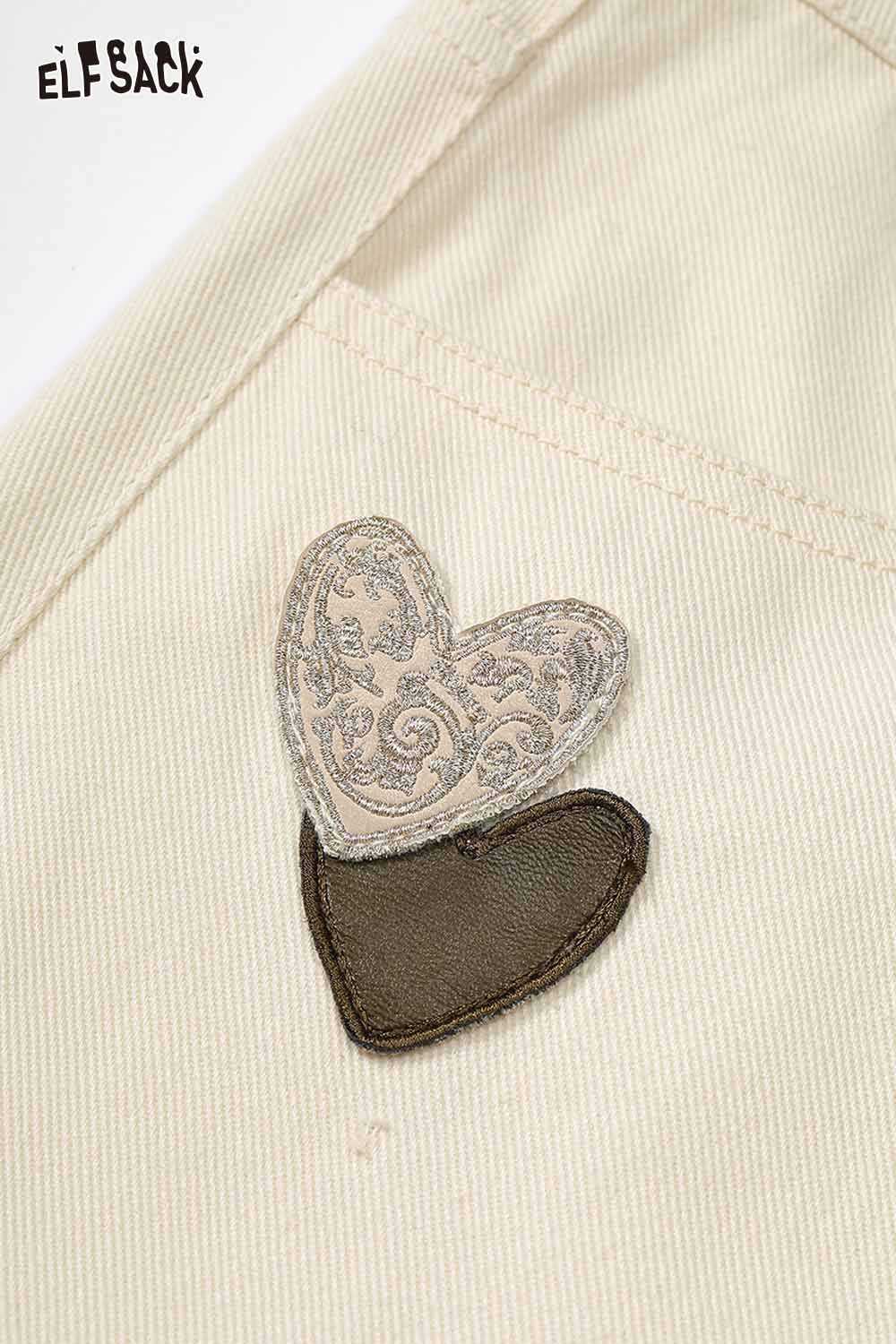 Close-up of heart embroidery on ELFSACK white wide leg jeans showcasing detailed design